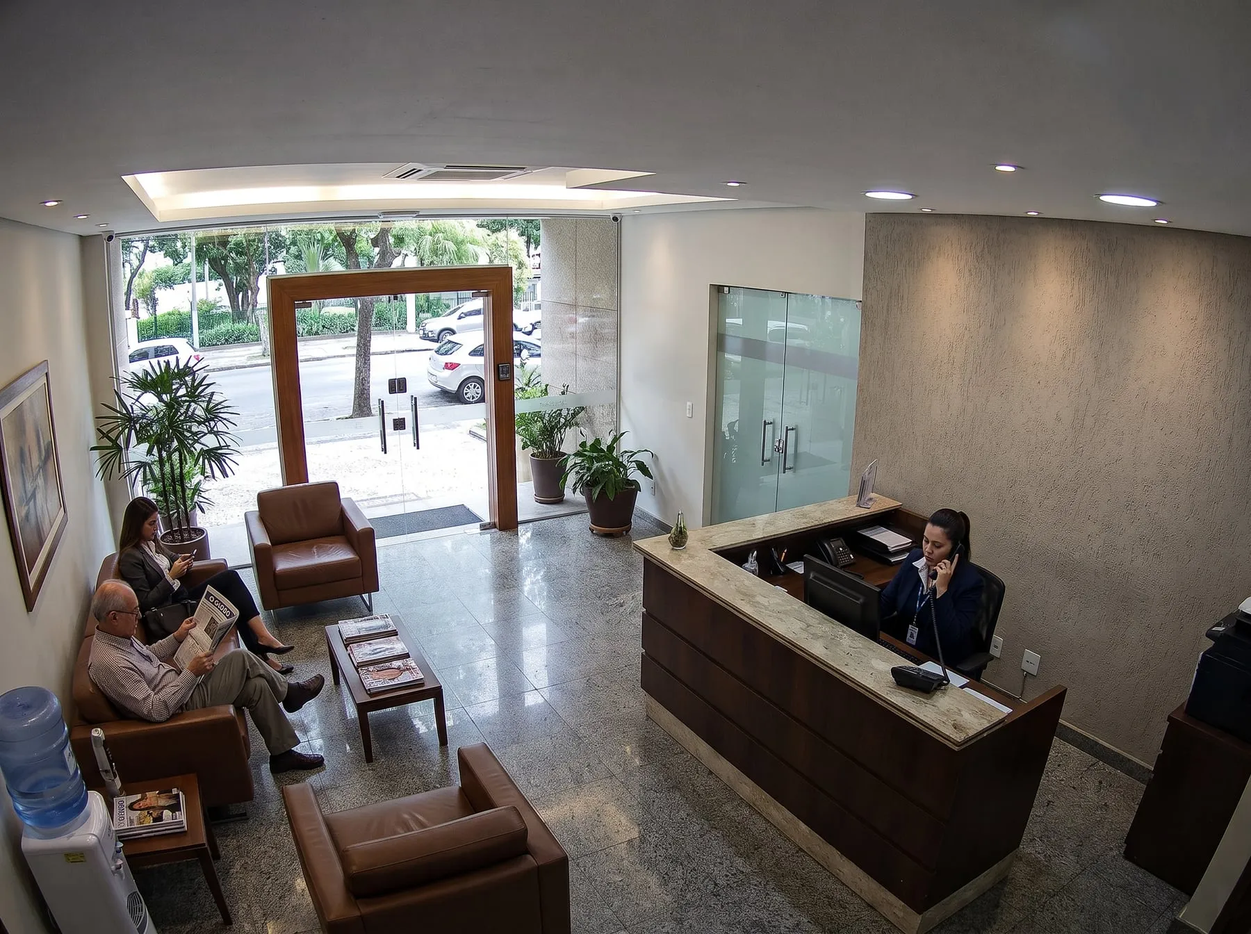 Câmera no teto da recepção de uma empresa mostrando a entrada, o balcão e a sala de espera